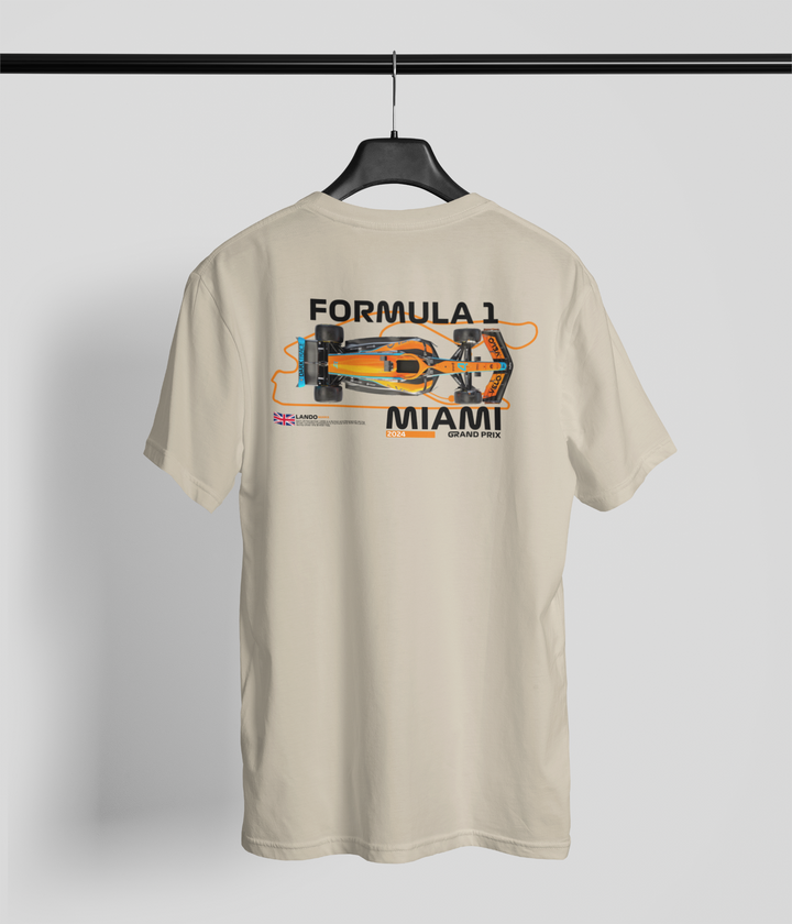 Beige t-shirt with Formula 1 Miami graphic on a hanger against a light gray background