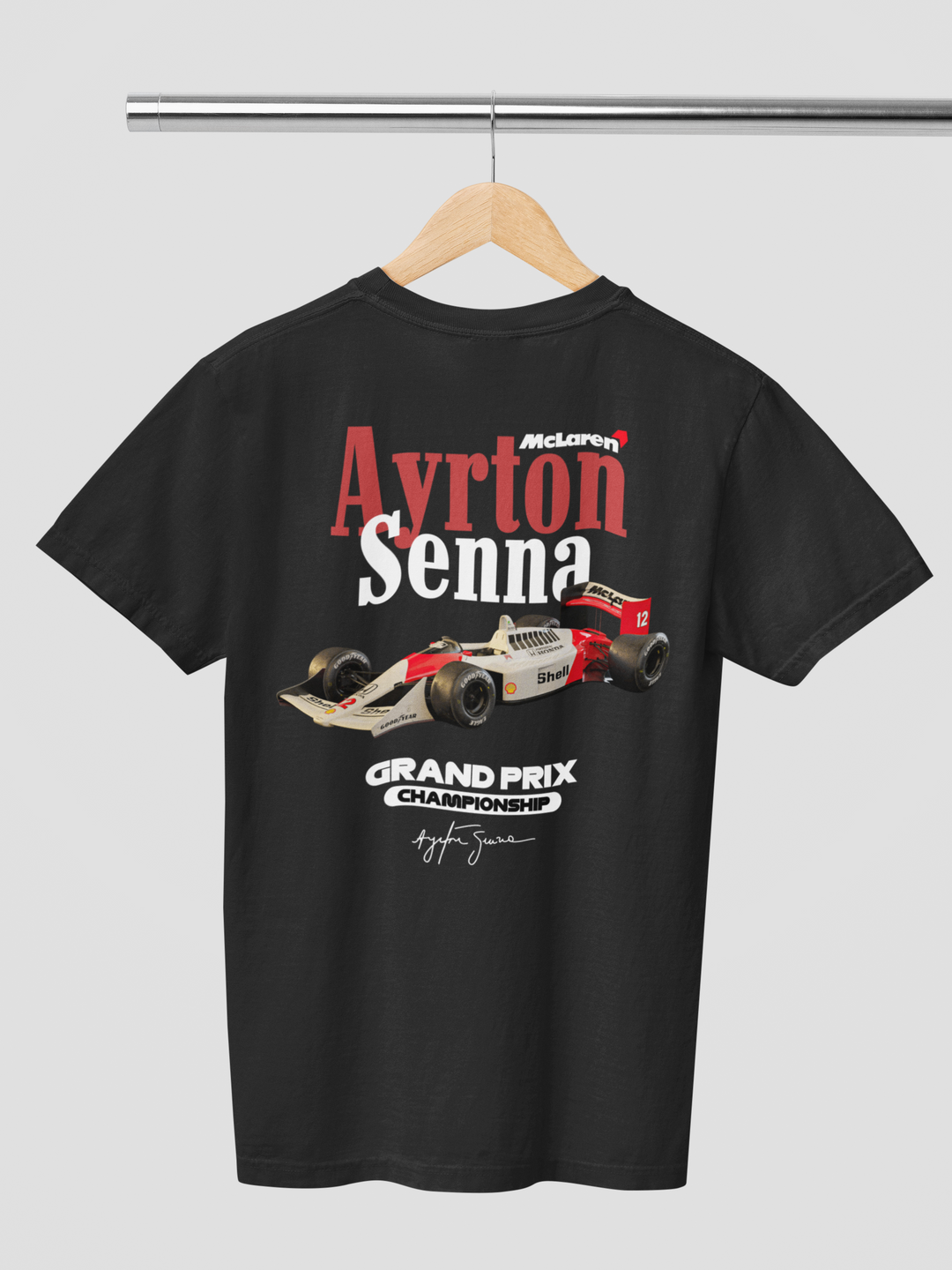 Black t-shirt with Ayrton Senna McLaren Grand Prix design on a hanger against a gray background